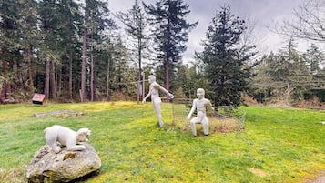 A sculpture garden with three figures and a bear on a rock.
