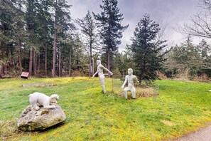 A sculpture garden with three figures and a bear on a rock.