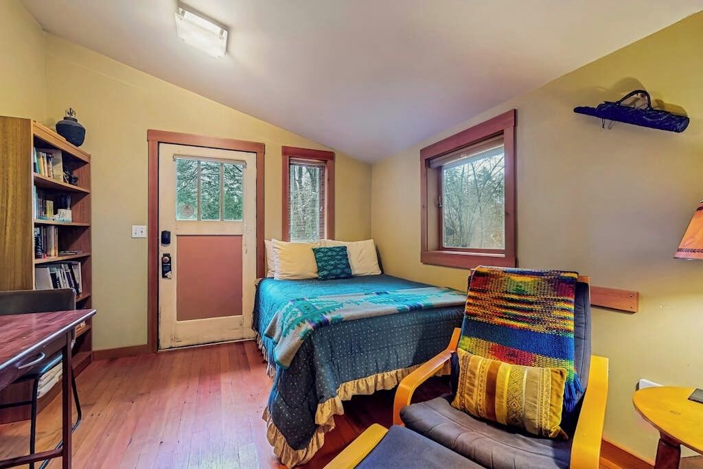 Une chambre à coucher avec un lit, une chaise, un bureau et une bibliothèque.