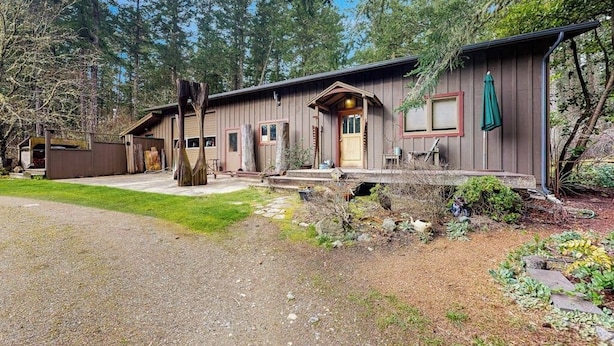 A rustic cabin with a porch, a covered entryway, and a small deck. - Dog Friendly Studio with Kitchenette, WiFi, Yard and Fire Pit near Eastsound Beach (Eastsound)