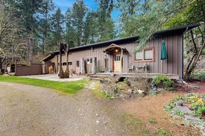 A rustic cabin with a porch, a covered entryway, and a small deck.