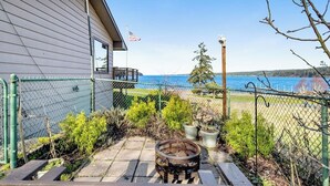 A house with a view of the sea, a flag, and a wooden barrel. - Spacious Dog Friendly 5 Bedroom Beachfront Home with Fenced Yard (Freeland)