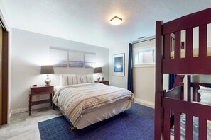 A bedroom with a bed, bedside tables, a lamp, a window, and a door.