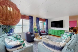 A living room with a large window, a flat-screen TV, and a green cabinet.