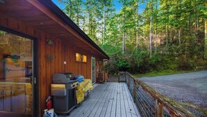 Eine Holzhütte mit einer Veranda, umgeben von Wald.