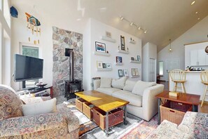 Un salon comprenant un canapé, une table basse, un téléviseur et une cheminée.