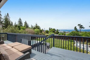 Eine Terrasse mit Gartenmöbeln und Meerblick, ausgestattet mit einem Holzgeländer.