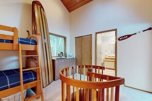 Ein Zimmer mit Etagenbetten, einem Schreibtisch, einem Spiegel und einer Fledermaus an der Wand.