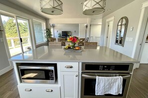A kitchen with a built-in microwave, oven, and a central island with a fruit bowl. - Spacious Family Home with Game Room in Eastsound (Eastsound)