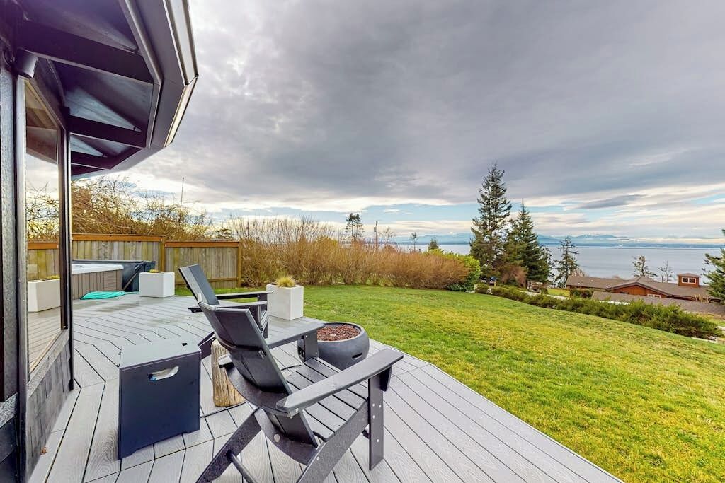 Eine Terrasse mit Gartenmöbeln und Blick auf das Wasser.