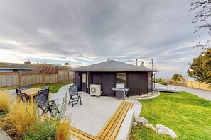 Ein Garten mit Grillplatz, Sitzgelegenheiten im Freien und Blick auf den Ozean.