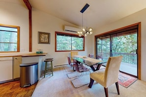 A dining area with a table, chairs, and a view of the outdoors. - Pet Friendly Mountain View Retreat on Orcas Island with BBQ and Patio (Orcas Island)