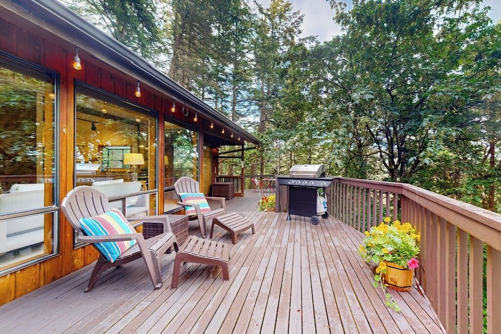 Una terrassa de fusta amb seients exteriors i una barbacoa.