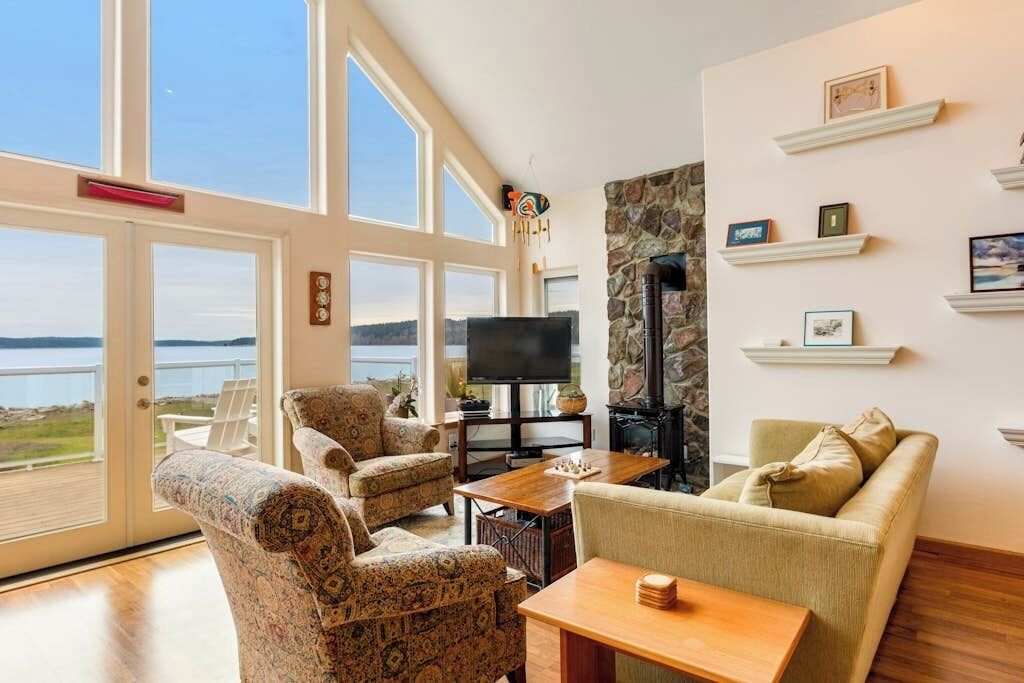 Ein Wohnzimmer mit großem Fenster, Fernseher und Kamin.