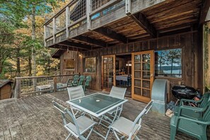 A rustic cabin with a deck, outdoor seating, and a grill. - Spectacular Waterfront Cabin in Eastsound with Private Deck and Mountain Views (Eastsound)
