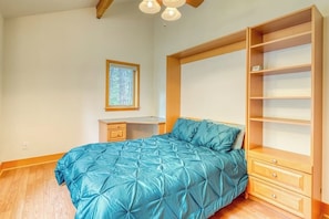 A bedroom with a bed, a desk, and a built-in wardrobe. - Stunning Water View Retreat with Fireplace, Huge Deck, and Jetted Tub (Eastsound)