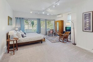 Ein Schlafzimmer mit einem Bett, Nachttischen, einem Schreibtisch und Stühlen.