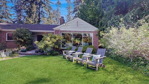 Une maison dotée d’un patio couvert, d’une pelouse et d’un espace salon extérieur.
