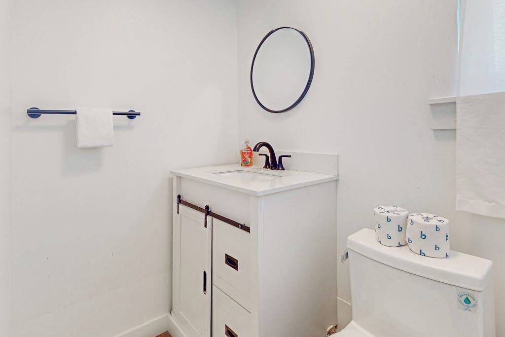 Une salle de bain avec un lavabo blanc, des toilettes et un porte-serviettes.