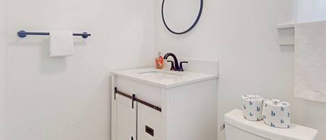 Une salle de bain avec un lavabo blanc, des toilettes et un porte-serviettes.