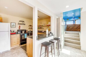 A kitchen with a central island, wooden cabinets, and a refrigerator.