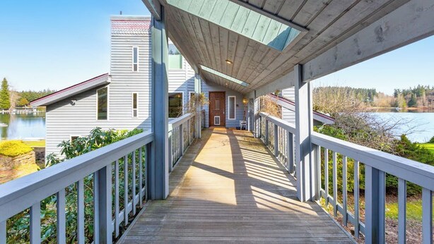 A wooden deck leading to a house with a view of a lake. - 4 BR Pet Friendly Waterfront Home with Game Room (Clinton)