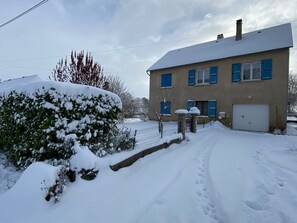 Una casa de dos pisos con techo nevado y un garaje.