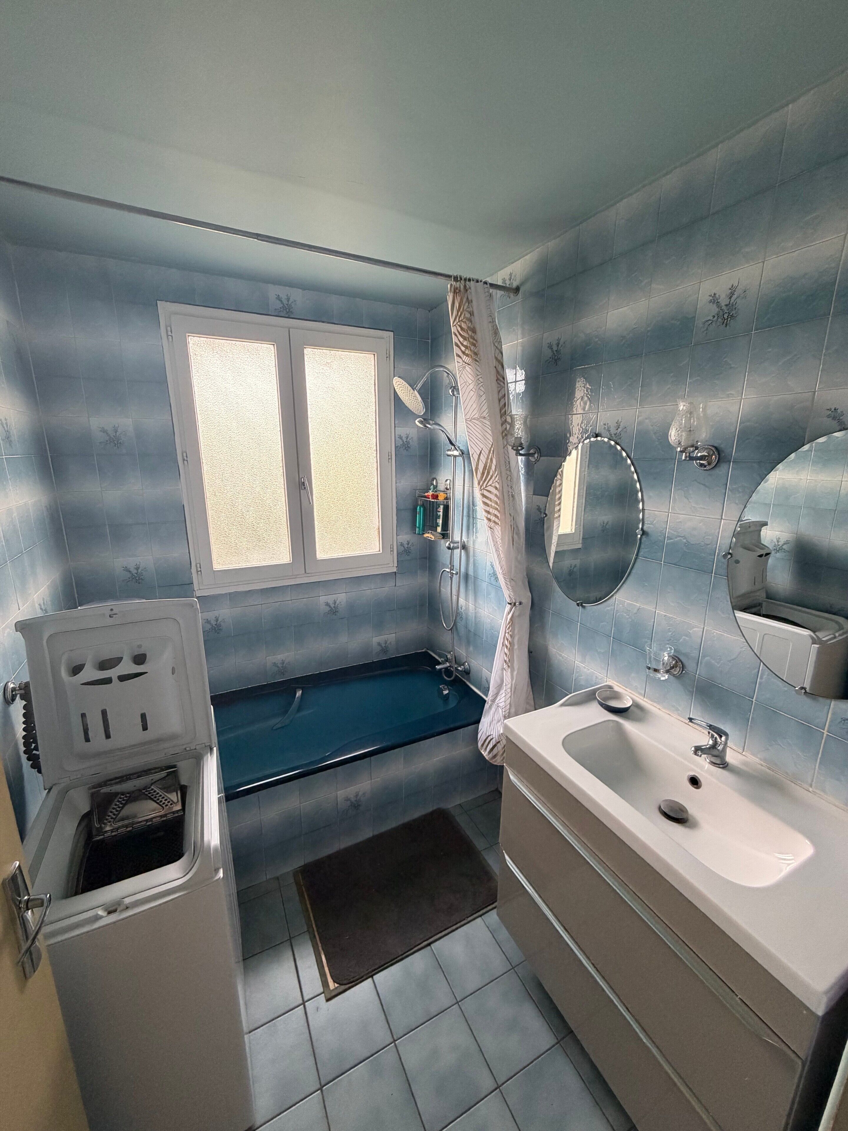 Un bagno con una vasca, un water, un lavandino e una finestra.