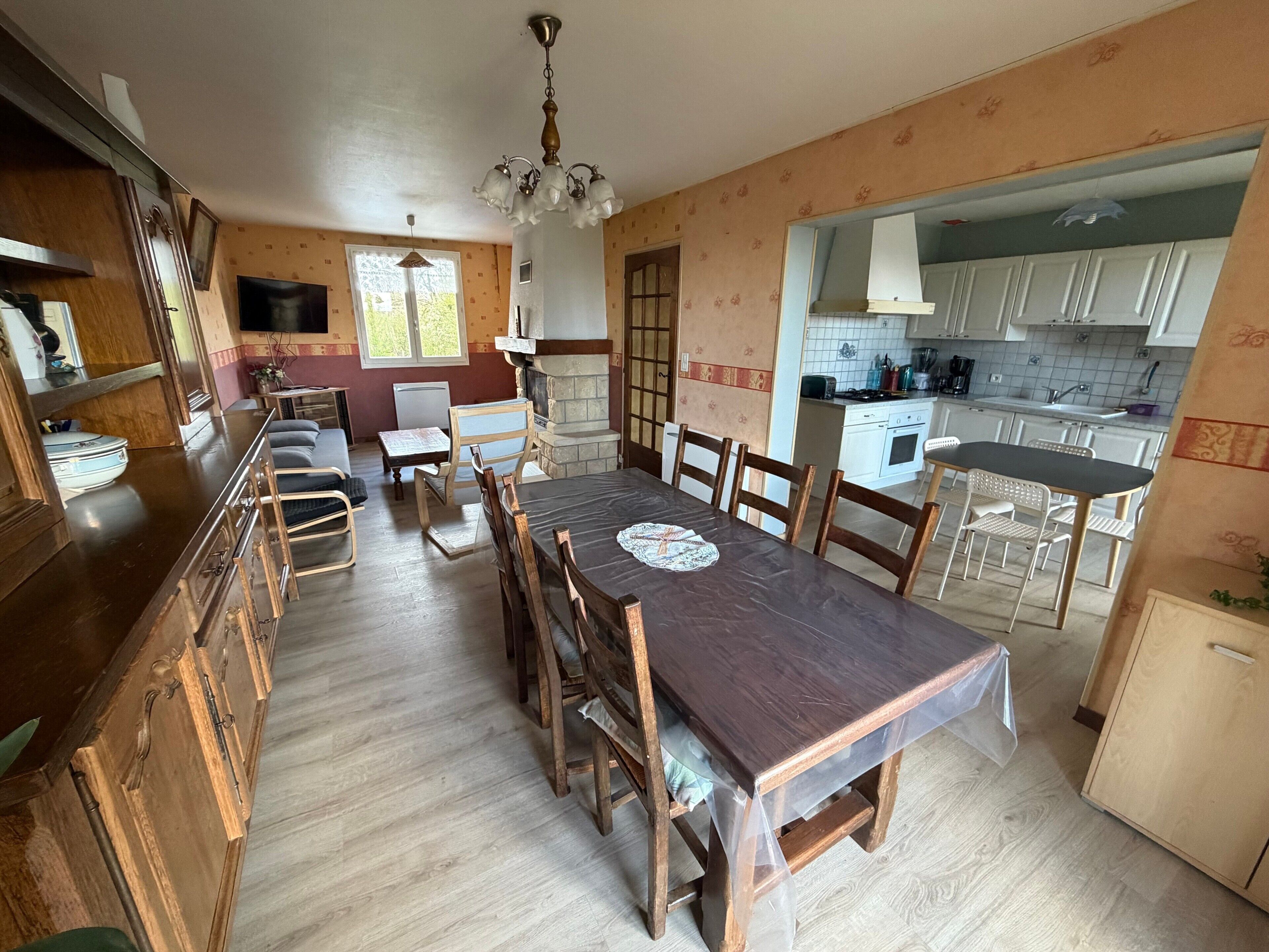 A spacious kitchen with a dining area, wooden cabinets, and a built-in oven.