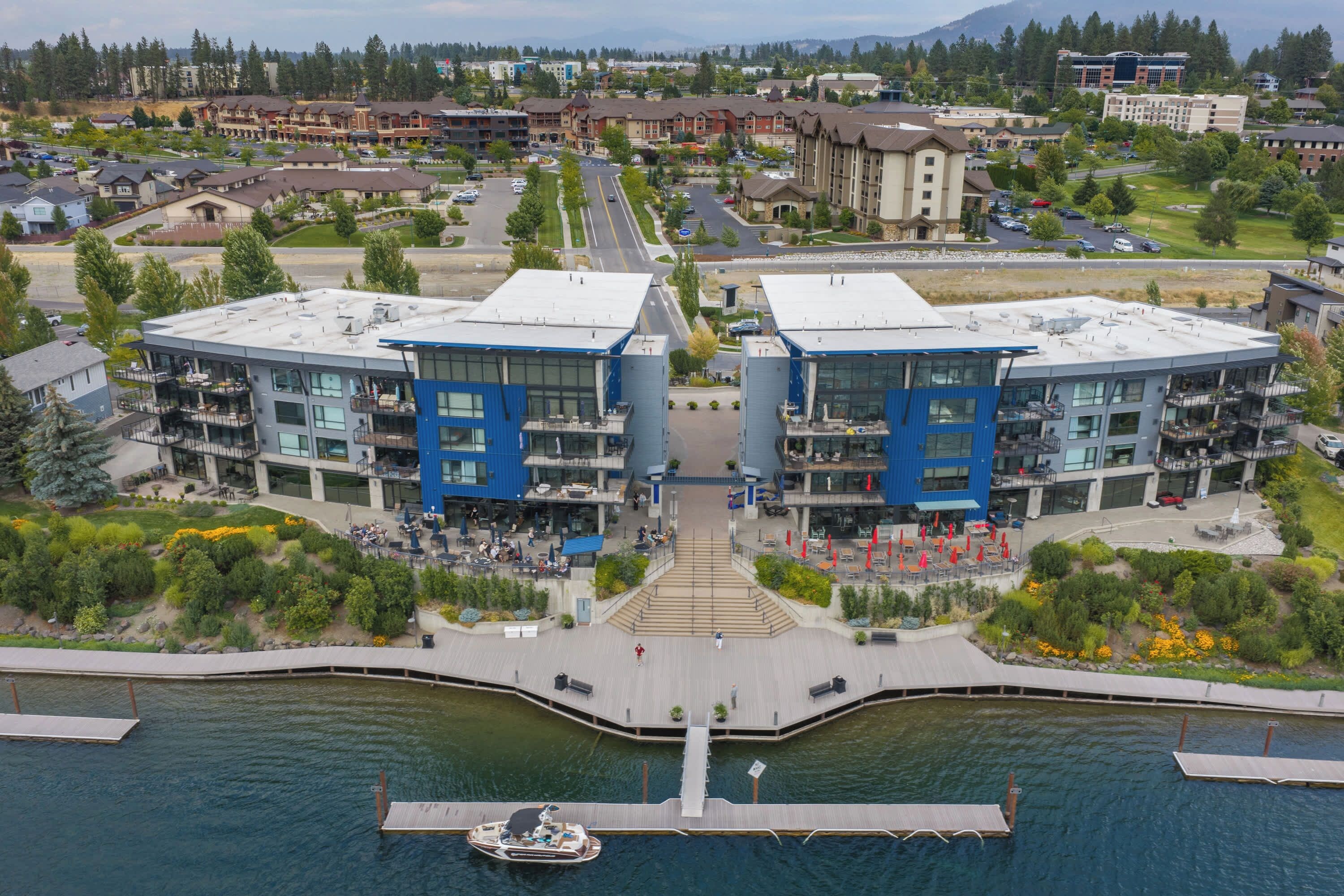 A waterfront hotel with a central courtyard, outdoor seating, and a dock.