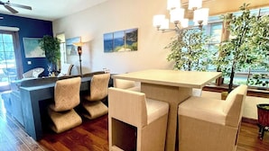 A modern kitchen with a bar area, wooden flooring, and a view of the outdoors. - Vesper Bleu  2 Kings + EV Charger (Coeur d'Alene)