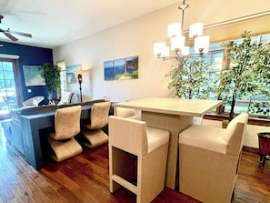 Eine moderne Küche mit Barbereich, Holzboden und Blick ins Freie.