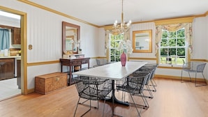 A dining area with a large table, chairs, a chandelier, and a view of the outdoors. - 
The Bishop Retreat  5BR, Tennis Court & Yard (Alexandria)