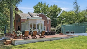 A brick house with a covered patio area featuring outdoor furniture and a pool. - 
The Bishop Retreat  5BR, Tennis Court & Yard (Alexandria)