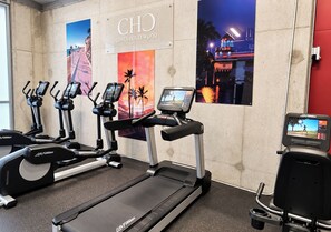 A fitness area with treadmills and elliptical machines, a Life Fitness brand, and a wall with a 'CHO COSTA HOLLYWOOD' sign. - Special Apartment 6 pax with den beachfront (Hollywood)