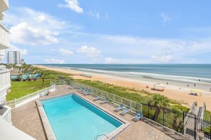 A pool area with a view of the beach and ocean. - New Listing! Updated Oceanfront 2/2 | Heated Pool & Garage Parking (Ormond Beach)