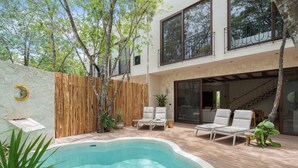 A modern house with a swimming pool, outdoor seating, and a staircase leading to a second floor. - "Rana Curiosa" @BlueDeerTulum - 4 Bed+4.5 Bath LUX Villa - Pool, Jacuzzi, Staff (Tulum)