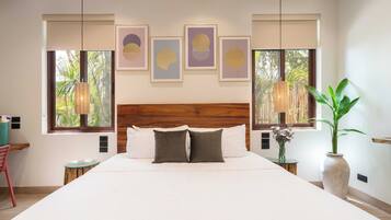 Quarto com uma cama grande, cabeceira de madeira e obras de arte na parede.