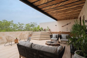A rooftop terrace with a thatched roof, outdoor seating, and a decorative wall. - LUX 4BR/4.5 Bath Villa - Private Pool & Hot Jacuzzi +Staff - BLUE DEER TULUM (Tulum)