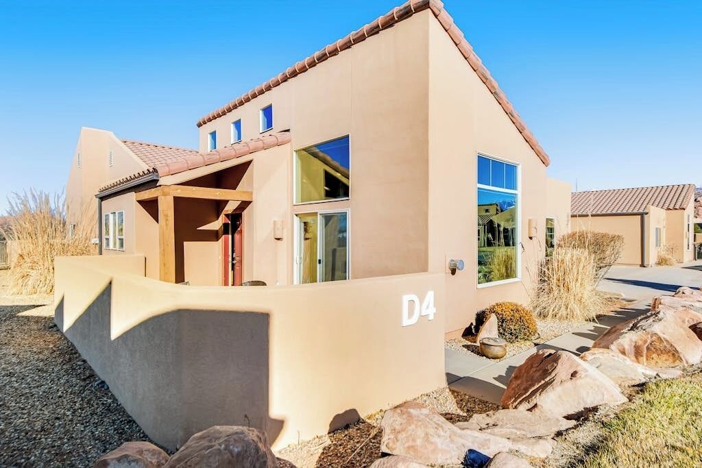 Una casa moderna con techo plano, ventanas amplias y el número 'D4' en la fachada.