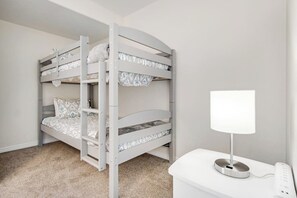 A bunk bed with a white lamp on a bedside table. - Remodeled Townhouse with Pool, Private Hot tub & Fireplace - Near National Park (Moab)