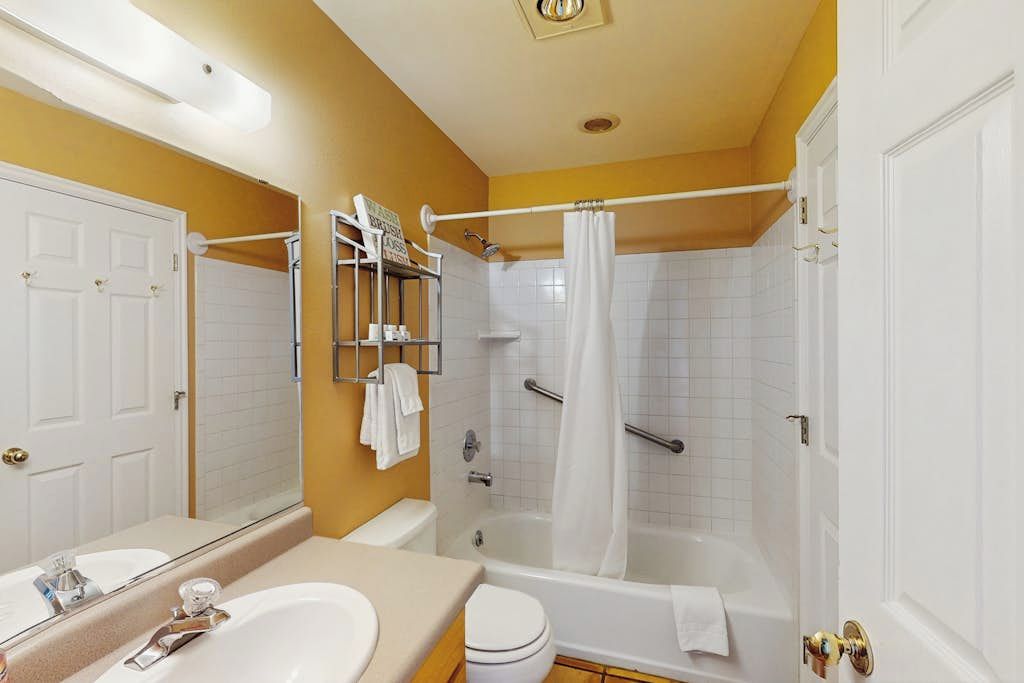 A bathroom with a bathtub, toilet, and sink.
