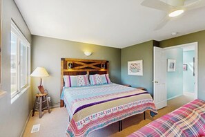 A bedroom with a bed, bedside table, lamp, and a door. - Condo with Beautiful Red Rock Vistas, Seasonal Pool, Fireplace, Grill, and WiFi (Moab)