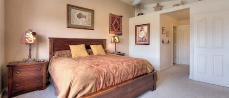 Quarto com cama de madeira, ventilador de teto e piso coberto por carpete.