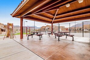 An outdoor patio area with picnic tables and a covered seating area. - Lovely Condo With Cozy Fireplace & Mountain Views - Great Location (Moab)