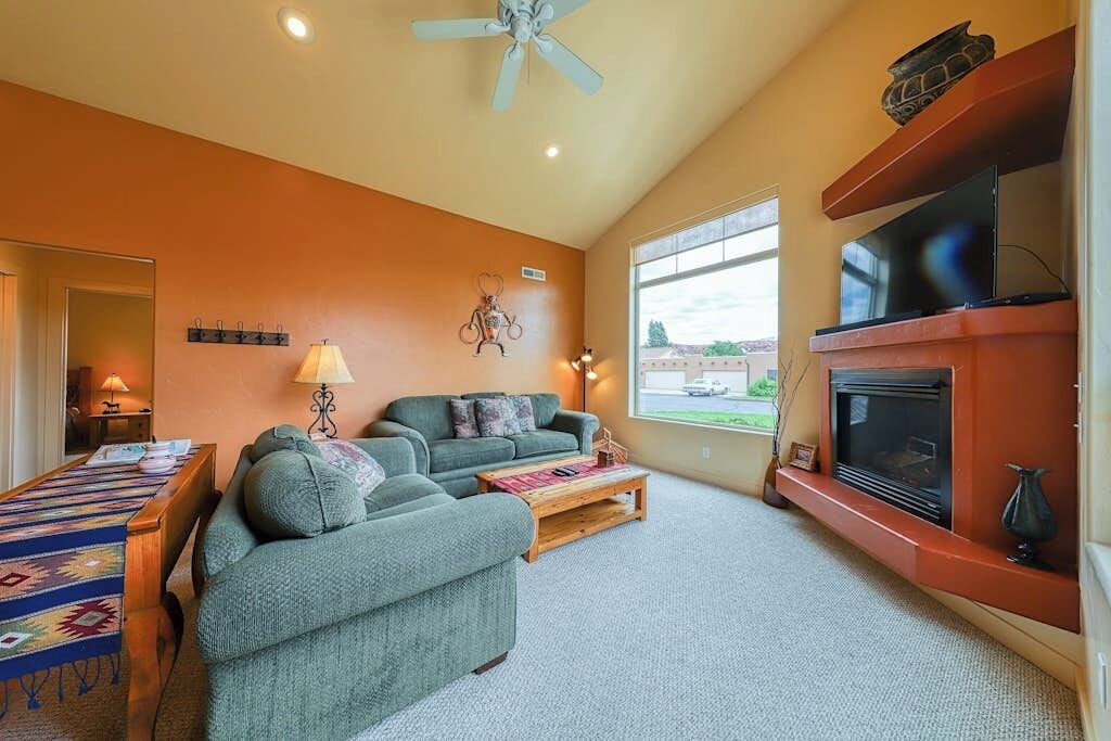 Una sala de estar con sofá, mesa de centro, chimenea y televisor.