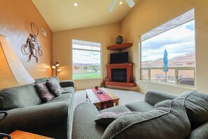 A living room with a sofa, a coffee table, and a fireplace. - Lovely 3BR Mountainview with Pool and Hot Tub (Moab)