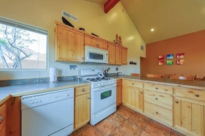 A kitchen with wooden cabinets, a white stove, and a microwave. - Lovely 3BR Mountainview with Pool and Hot Tub (Moab)