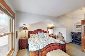 A bedroom with a large bed, a nightstand, a chair, and a dresser. - Luxury Home with Spectacular Views and Hot Tub - Walk to Golf Course (Moab)