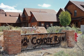 Um edifício rústico com uma placa que diz 'Coyote Run'.